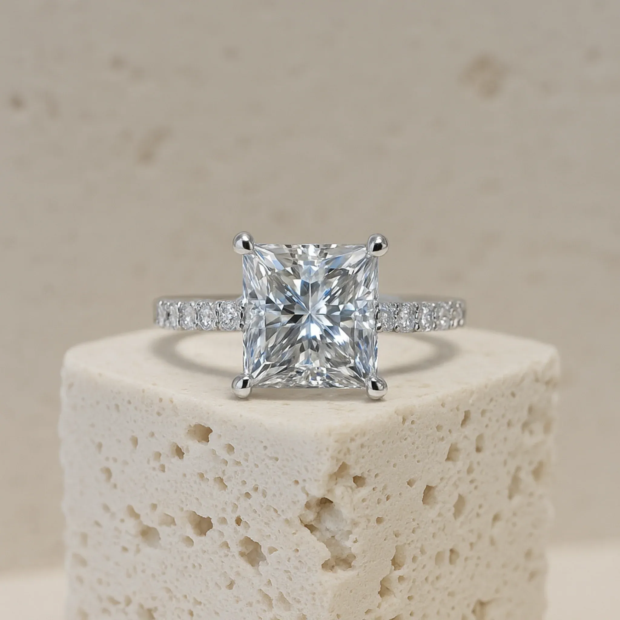 A princess-cut solitaire ring made by Vulcan, with a pavé-set shank.